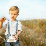 Boy playing with toy wind turbine outdoors