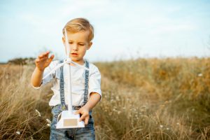 Boy playing with toy wind turbine outdoors